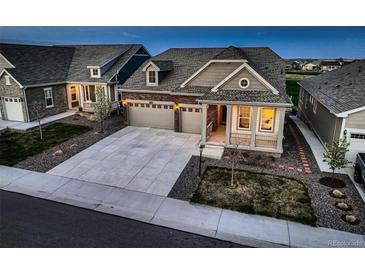 Inviting home featuring a manicured lawn, stone accents, and an attached two car garage at 15788 Valentia St, Thornton, CO 80602