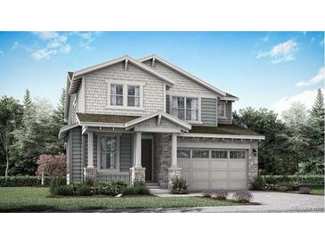 Charming two-story home featuring a two-car garage, stone accents, and a beautifully landscaped front yard at 7377 S Yank Ct, Littleton, CO 80127