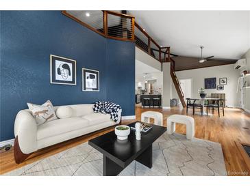 Modern living room with hardwood floors, stylish furniture, and a high ceiling with a view to the second story at 1100 N Logan St # 9, Denver, CO 80203