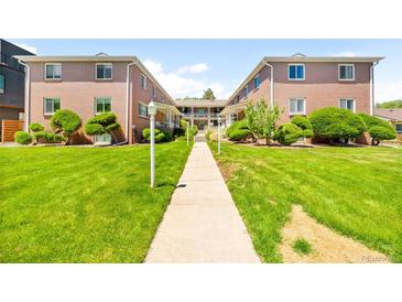Beautiful two-story brick apartment building with lush green landscaping and a walking path at 2047 S Milwaukee St # 4, Denver, CO 80210