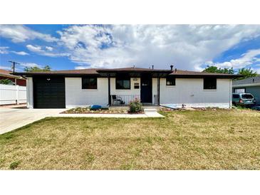 Charming single-story white home featuring a well-manicured lawn, black trim, and inviting curb appeal at 7150 Beach St, Westminster, CO 80030