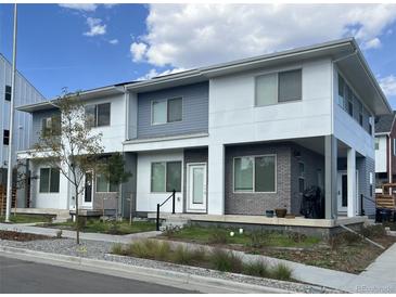 Modern two-story townhome with gray and white exterior and small front yard at 15243 W 69Th Ave, Arvada, CO 80007