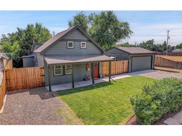 Charming exterior of a home with a red door, green lawn, and detached garage at 2310 S Decatur St, Denver, CO 80219