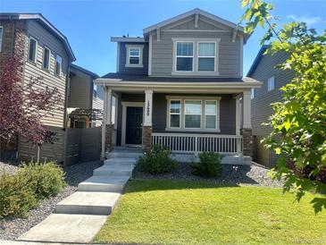 Charming two-story home features a covered front porch and a well-manicured lawn at 15600 Bolling, Denver, CO 80239