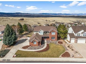 Beautiful two-story home with brick accents and a well-manicured lawn and beautiful mountain view at 3603 Soaring Eagle Ct, Castle Rock, CO 80109
