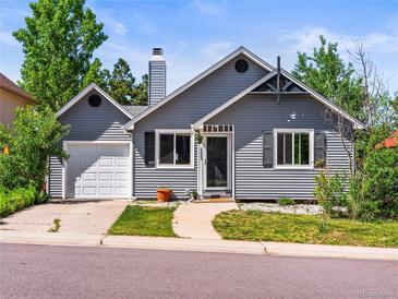 Charming gray home featuring a well-manicured lawn and a driveway leading to an attached one car garage at 4453 S Pagosa Way, Aurora, CO 80015