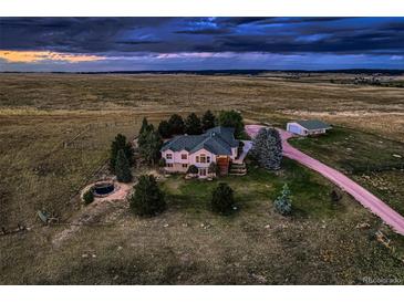 Expansive rural estate featuring a sprawling home with lush landscaping and a separate outbuilding at 3487 Willownook Ranch Trl, Elizabeth, CO 80107