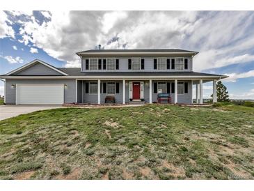Charming two-story home with a welcoming front porch and well-manicured lawn, perfect for relaxing outdoors at 35427 Welch Trl, Elizabeth, CO 80107
