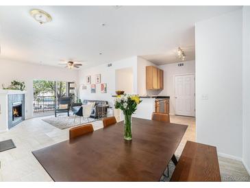 Bright, open-concept living space features a fireplace and access to a balcony, seamlessly connecting indoor and outdoor living at 4451 S Ammons St # 4-108, Littleton, CO 80123