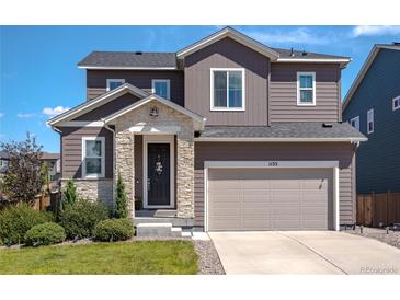 Charming two-story home with a stone-accented entrance and a well-manicured front yard at 1135 Basalt Ridge Loop, Castle Rock, CO 80108