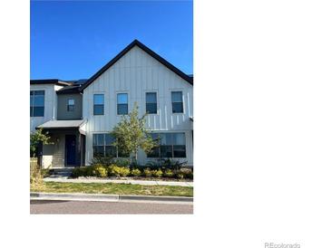 Charming two-story home featuring eye-catching vertical siding and a beautifully landscaped front yard at 9637 E 56Th Pl, Denver, CO 80238