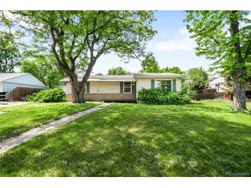Charming ranch-style home featuring a spacious front yard with mature tree coverage at 4616 E Yale Ave, Denver, CO 80222