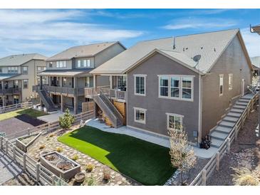 Landscaped backyard with wood fence, small patio, artificial turf area, and stone walkway to the main house at 8099 Arapahoe Peak St, Littleton, CO 80125