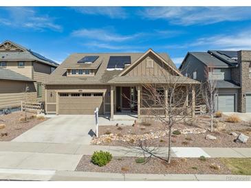Charming single-Gathering home with a two-car garage, a covered porch, desert landscaping and solar panels at 8099 Arapahoe Peak St, Littleton, CO 80125