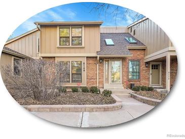 Charming townhome featuring a brick facade, well-maintained landscaping, and inviting front entrance at 8166 E Phillips Ave, Centennial, CO 80112