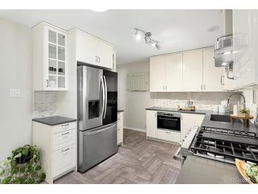 Modern kitchen with stainless steel appliances, white cabinets, and gray countertops offers a stylish cooking space at 6314 Brooks Dr, Arvada, CO 80004