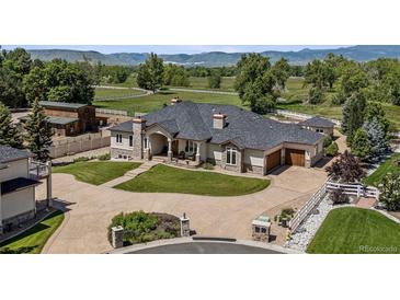 Stunning exterior showcases a landscaped yard, circular driveway, and well-maintained traditional home at 13962 W 76Th Ln, Arvada, CO 80005