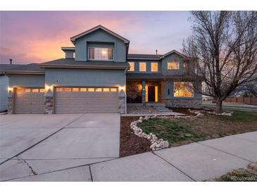 Charming two-story home with stone accents, three-car garage, and manicured front yard under a colorful evening sky at 3685 Roberts St, Mead, CO 80542