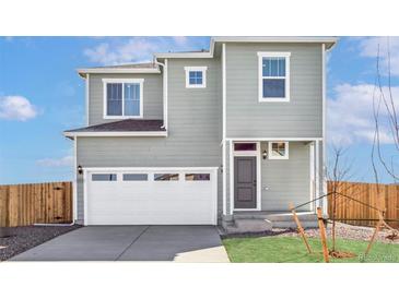 Charming two-story home featuring a spacious garage, well-manicured lawn, and classic architectural details at 17942 E 94Th Pl, Commerce City, CO 80022