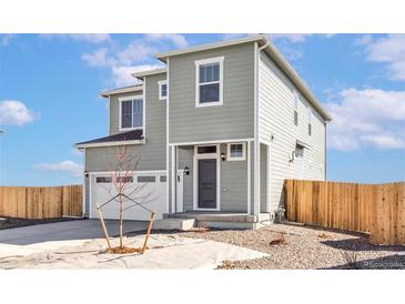 Charming two-story home with gray siding, a two-car garage, and a well-manicured front yard at 17942 E 94Th Pl, Commerce City, CO 80022