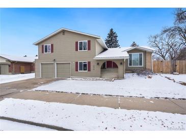 Charming two-story home with an attached two-car garage and snow covered yard at 7076 W 83Rd Way, Arvada, CO 80003