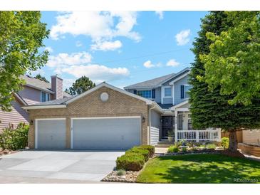 Charming two-story home with a manicured front yard, a two-car garage, and a welcoming entryway at 5134 S Ouray Ct, Centennial, CO 80015