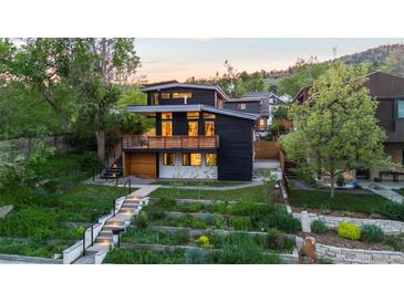 Modern two-story home with a wood balcony, stylish architecture, and tiered landscaping at 2725 6Th St, Boulder, CO 80304