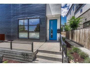 Modern home featuring a sleek exterior, a vibrant blue front door, and manicured landscaping at 1231 Newton St, Denver, CO 80204