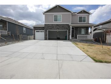 Two-story home featuring a large concrete driveway and an attached garage with a stone and light gray facade at 4955 Trails Edge Ln, Castle Rock, CO 80104