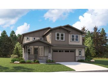 Charming two-story home with covered porch, neutral siding, well manicured lawn, and an attached two-car garage at 8338 Snake River St, Littleton, CO 80125