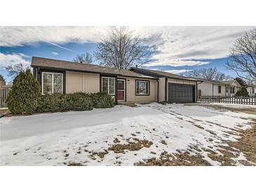 Ranch-style home with a snow-covered yard and attached garage at 6196 W 66Th Ave, Arvada, CO 80003