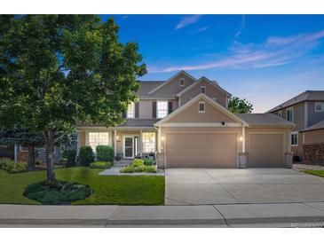 Charming two-story home features a well-manicured lawn, mature tree and a three car garage at 12000 Pine Top St, Parker, CO 80138