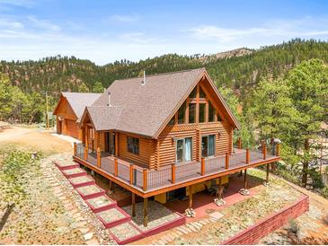 Charming log home featuring a spacious deck, natural wood finishes, and mountain views at 9868 Overlook Rd, Sedalia, CO 80135