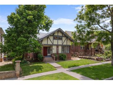 Charming Tudor-style home with a well-manicured lawn and mature trees at 1020 10Th St, Boulder, CO 80302