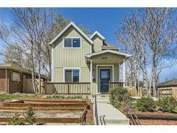 Charming two-story home featuring a cozy front porch and landscaped garden at 3225 Olive St, Denver, CO 80207