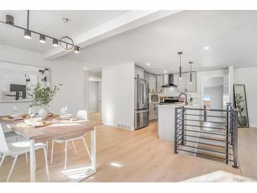 Bright dining area with wood table and modern light fixture at 5565 W Arizona Ave, Lakewood, CO 80232