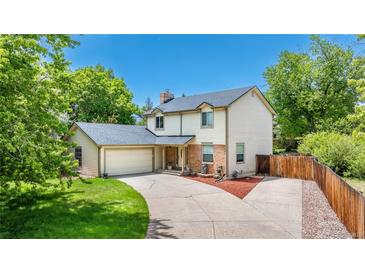 Beautiful two-story home with an attached garage, lush lawn, and a long driveway on a sunny day at 4571 S Memphis St, Aurora, CO 80015