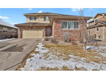 Charming two-story home features a brick and siding exterior, attached garage, and a well-maintained front yard at 247 N Coolidge Way, Aurora, CO 80018