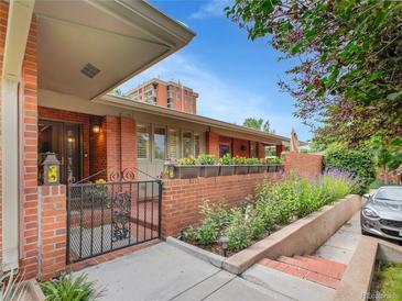 Charming brick home with a gated entrance and beautiful flower boxes, offering a warm and inviting curb appeal at 3481 S Race St, Englewood, CO 80113