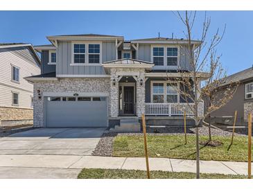 Beautiful two story home featuring a gray exterior with white brick accents, and a two car garage at 647 Nightsky St, Erie, CO 80516
