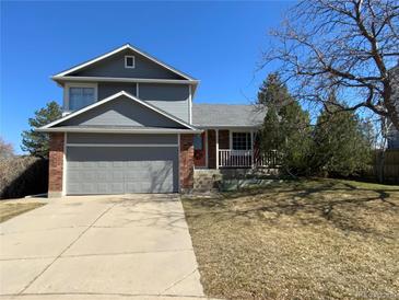 Charming two-story home with a well-maintained lawn, a covered front porch, and an attached two-car garage at 4996 S Gibraltar Way, Centennial, CO 80015