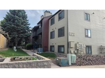 The exterior shows the building, sidewalk, and landscaping of this residence at 10890 W Evans Ave # 2E, Lakewood, CO 80227