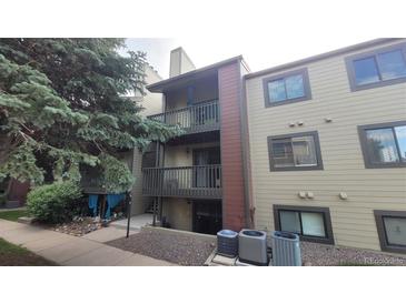 Inviting condo exterior featuring balconies, neutral siding, and well-maintained landscaping at 10890 W Evans Ave # 2E, Lakewood, CO 80227