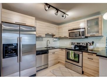 Bright kitchen featuring stainless steel appliances, stylish cabinetry and plenty of counter space at 120 S Pennsylvania St # 302, Denver, CO 80209