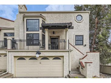 Charming two-story stucco home with a balcony, two-car garage, and a decorative circular window at 1600 S Quebec Way # 8, Denver, CO 80231