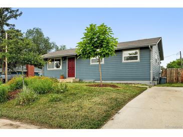 Charming single-story home with blue siding, a red door, and a well-maintained front yard and walkway at 2011 S Vallejo St, Denver, CO 80223
