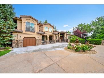 Stunning stucco home with stone accents, a water fountain, and a basketball court at 6783 E Orchard Rd, Greenwood Village, CO 80111