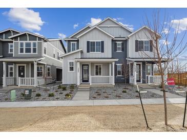 Charming townhome featuring a covered front porch and contemporary gray and white exterior at 1242 Penner Dr, Erie, CO 80026