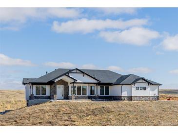 Stunning single-story home with white siding, dark trim, and a stone foundation on a large lot at 5424 Freddys Trl, Parker, CO 80134