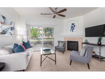 Bright living room featuring a ceiling fan, fireplace, and sliding glass doors to a balcony at 8200 E 8Th Ave # 8101, Denver, CO 80230